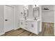 Bathroom with dual vanity, white cabinets, modern fixtures, and wood-look flooring at 336 Fond Du Lac Dr, Stone Mountain, GA 30088