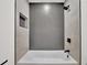 Bright bathroom features white tub and shower with decorative tile, and black fixtures at 336 Fond Du Lac Dr, Stone Mountain, GA 30088