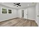Bright bedroom features a ceiling fan, wood-look floors, fresh paint, and a view of the lush outdoors at 336 Fond Du Lac Dr, Stone Mountain, GA 30088