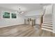Open-concept living room boasts stylish light fixture, wood floors, and staircase at 336 Fond Du Lac Dr, Stone Mountain, GA 30088