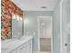 Stylish bathroom with double sink vanity, floral accent wall, and shower at 3451 Falls Branch Ct, Buford, GA 30519