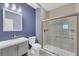 Modern bathroom features a shower with glass door, sleek vanity, and blue walls at 3451 Falls Branch Ct, Buford, GA 30519