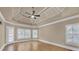Spacious bedroom featuring a tray ceiling, ceiling fan, and large windows at 3451 Falls Branch Ct, Buford, GA 30519