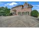 Brick home featuring a multi-car garage and a spacious driveway for convenient parking at 3451 Falls Branch Ct, Buford, GA 30519