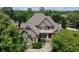 Aerial view of a brick home surrounded by lush trees and landscaped yard at 3451 Falls Branch Ct, Buford, GA 30519