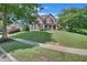 Charming two-story brick home with a lush, green lawn and mature trees at 3451 Falls Branch Ct, Buford, GA 30519