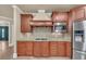 Open kitchen featuring stainless steel appliances, cherry cabinets and hardwood floors at 3451 Falls Branch Ct, Buford, GA 30519