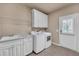 Well-equipped laundry room with ample counter space and modern washer and dryer at 3451 Falls Branch Ct, Buford, GA 30519