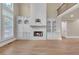 Spacious living room with hardwood floors, a fireplace, and built-in bookshelves at 3451 Falls Branch Ct, Buford, GA 30519