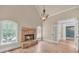 Bright living room with stone fireplace, hardwood floors, and arched windows at 3451 Falls Branch Ct, Buford, GA 30519