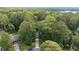 Aerial view of a home nestled among dense trees near a lake at 5679 Bay Harbor Nw Trl, Acworth, GA 30101