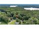 Aerial view of a home nestled among dense trees, with a lake nearby at 5679 Bay Harbor Nw Trl, Acworth, GA 30101