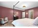 Elegant bedroom featuring a four-poster bed and cozy sitting area, accented by unique rose-colored walls at 5679 Bay Harbor Nw Trl, Acworth, GA 30101