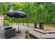 Outdoor deck with seating, an umbrella, and manicured lawn, providing relaxation with wooded views at 5679 Bay Harbor Nw Trl, Acworth, GA 30101