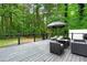 Spacious deck with outdoor furniture and umbrella, surrounded by lush greenery at 5679 Bay Harbor Nw Trl, Acworth, GA 30101
