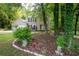 Landscaped front yard featuring mature trees and blooming plants at 5679 Bay Harbor Nw Trl, Acworth, GA 30101