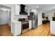 Stylish kitchen with white cabinets, stainless steel appliances, and a modern range hood; well-lit and functional at 5679 Bay Harbor Nw Trl, Acworth, GA 30101