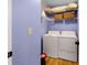 Cozy laundry room with washer, dryer, wire shelves, and ample storage space at 5679 Bay Harbor Nw Trl, Acworth, GA 30101