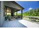 A covered deck showing an open-air living space, with a stone fireplace, television, fan and natural views at 1231 Fawndale Nw Dr, Kennesaw, GA 30152