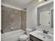 Bright bathroom featuring a tub with tiled walls, toilet, and sink with large mirror at 1231 Fawndale Nw Dr, Kennesaw, GA 30152