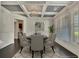 Elegant dining room featuring coffered ceilings, a modern chandelier, and ample natural light from large windows at 1231 Fawndale Nw Dr, Kennesaw, GA 30152