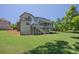 Expansive backyard and exterior view with covered porch and staircase, showcasing outdoor living space and mature trees at 1231 Fawndale Nw Dr, Kennesaw, GA 30152