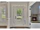 Bright front door with glass panels, allowing natural light to illuminate the entryway and fireplace at 1231 Fawndale Nw Dr, Kennesaw, GA 30152
