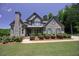 Charming two-story brick home with a lush, landscaped front yard and a welcoming front porch at 1231 Fawndale Nw Dr, Kennesaw, GA 30152