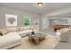 Bright living room with a stylish sectional sofa, modern coffee table, and an inviting adjacent billiard room at 1231 Fawndale Nw Dr, Kennesaw, GA 30152