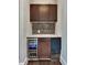 Stylish wet bar with dark wood cabinets, mosaic backsplash, marble countertop, wine cooler, and ice maker at 1231 Fawndale Nw Dr, Kennesaw, GA 30152