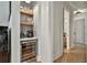 Hallway bar area with beverage cooler, sink, and decorative shelves at 175 Central Ave, Fayetteville, GA 30214