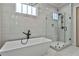 Bright bathroom features a modern white tub, sleek fixtures, and a glass-enclosed shower at 175 Central Ave, Fayetteville, GA 30214