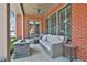 View of the stylishly furnished covered porch, perfect for entertaining, including fire pit and ceiling fans at 175 Central Ave, Fayetteville, GA 30214
