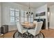 Elegant dining area with a round table, stylish chairs, and plantation shutters at 175 Central Ave, Fayetteville, GA 30214