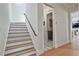Bright hallway with staircase and doorway to laundry room featuring decorative tile flooring at 175 Central Ave, Fayetteville, GA 30214