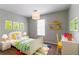 Bright bedroom with colorful decor, a desk, and ample natural light from large windows at 3694 Rolling Pl, Conley, GA 30288