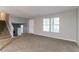 Bright living room featuring stairs, carpeted floors, and freshly painted neutral walls and trim at 3694 Rolling Pl, Conley, GA 30288