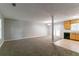 Open concept living room featuring a carpeted floor, neutral walls, and a kitchen with wood cabinets at 3694 Rolling Pl, Conley, GA 30288