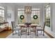 Dining room features large windows, a modern chandelier, and holiday wreaths at 4084 Peachtree Dunwoody Rd, Atlanta, GA 30342