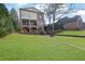 Rear exterior view of brick home with multiple porches and a large, level backyard at 4084 Peachtree Dunwoody Rd, Atlanta, GA 30342