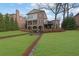 Back of house showing multiple porches, deck and a large green backyard and hardscape at 4084 Peachtree Dunwoody Rd, Atlanta, GA 30342