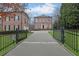 Stately brick home with black wrought iron fence and paved driveway leading to the front entrance at 4084 Peachtree Dunwoody Rd, Atlanta, GA 30342