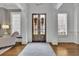 Elegant foyer with dark wood doors, white trim, and hardwood floors at 4084 Peachtree Dunwoody Rd, Atlanta, GA 30342