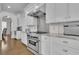 Well-equipped kitchen with stainless steel range, white cabinets, granite countertops, and hardwood floors at 4084 Peachtree Dunwoody Rd, Atlanta, GA 30342