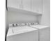 Bright laundry room featuring a washer, dryer, and white cabinets for ample storage space at 4084 Peachtree Dunwoody Rd, Atlanta, GA 30342