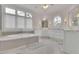 Bright bathroom with a large tub and many windows offering plenty of natural light at 4084 Peachtree Dunwoody Rd, Atlanta, GA 30342