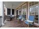Inviting covered porch featuring wicker seating and classic rocking chairs on a wood floor at 4084 Peachtree Dunwoody Rd, Atlanta, GA 30342