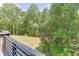 View of the grassy backyard and surrounding trees from an elevated deck or balcony at 4459 Grady Smith Rd, Loganville, GA 30052