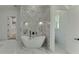 Luxury bathroom featuring a freestanding tub and marble-tiled accent wall at 4459 Grady Smith Rd, Loganville, GA 30052
