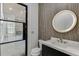 Stylish powder room with modern vanity, round mirror and decorative wall treatment at 4459 Grady Smith Rd, Loganville, GA 30052